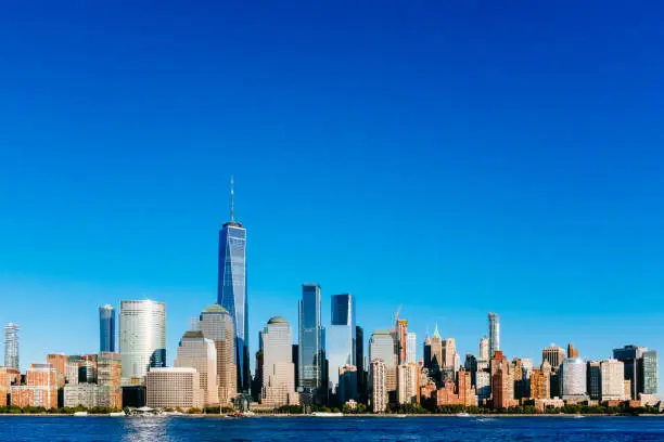 Photo of Skyline of downtown Manhattan over Hudson River under blue sky, at sunset, in New York City, USA