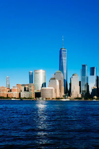 Photo of Skyline of downtown Manhattan over Hudson River under blue sky, at sunset, in New York City, USA