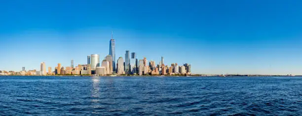 Photo of Panorama of skyline of downtown Manhattan over Hudson River under blue sky, in New York City, USA