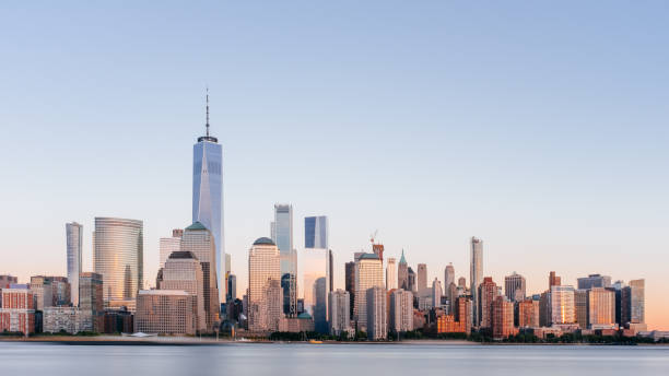 Skyline of downtown Manhattan over Hudson River under blue sky, at sunset, in New York City, USA stock photo