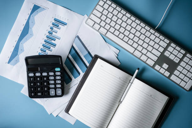 istock Office working desk table, The business hands hoilding a pen for note text with keyboard,notebook ,pen, eyeglasses,calculator. Top view background for copy space. 1069015332