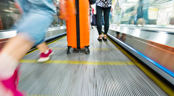 passeggero con valigia che cammina sulla passerella mobile - moving walkway escalator airport walking foto e immagini stock