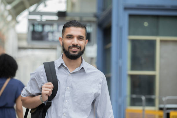 istock Young adult middle eastern man waits to board train 1069023450