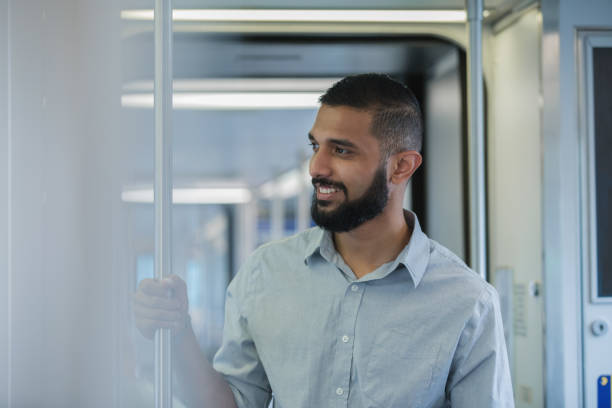 istock Young adult middle eastern male smiling while riding public transportation 1069023464