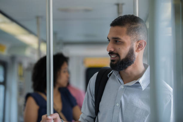 istock Young adult middle eastern male stands casually while riding public transportation 1069023478