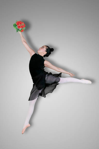istock Graceful ballerina is dancing with flowers 1069026594