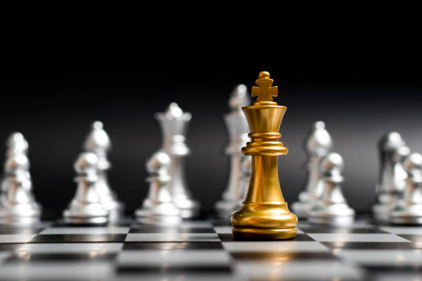 istock Gold king chess piece face with another silver team on black background (Concept for company strategy, business victory or decision) 1069026650