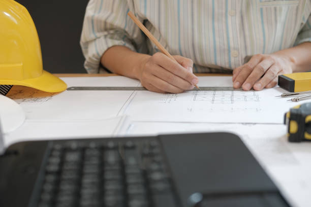 istock architect engineer working on house blueprint of real estate project at workplace. building construction concept 1069031154