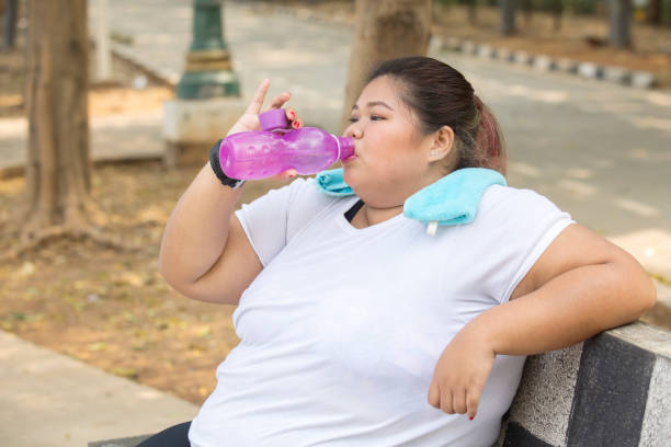 istock Fat woman drinks water after doing a workout 1069041556