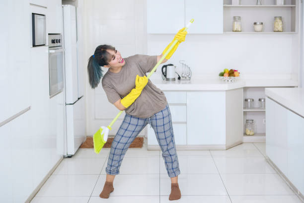 istock Happy housewife playing guitar with a broom 1069042796