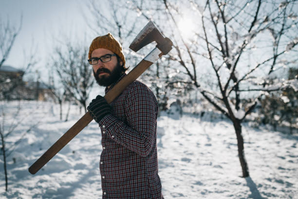istock Man cutting trees in the mountain on a snowy winter day 1069045712
