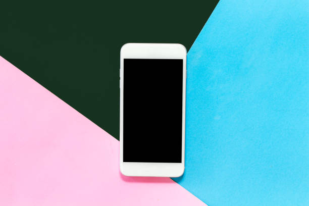 istock Top view of mockup smartphone with blank screen on blue and pink pastel background.technology and communication concept.Flat lay 1069047050