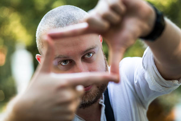 Young male photographer framing a shot using his fingers