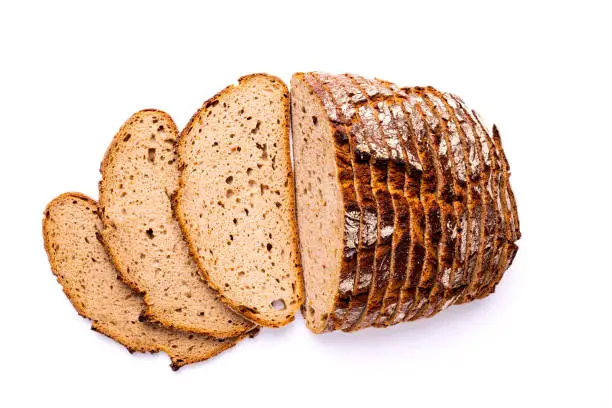 Loaf and slices of bread isolated on white background, view directly from above.