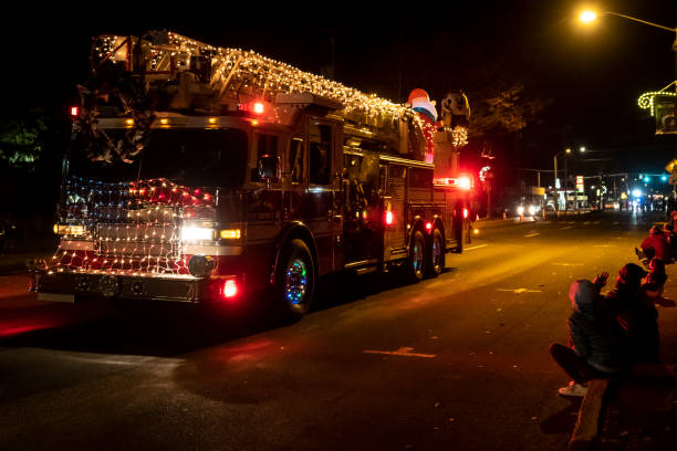 Sweet Home, Oregon, USA - November 9, 2018: The Sweet Home Capitol Christmas Tree Celebration was the kick off for the Capitol Tree’s travel. This photo is taken during the evening lighted Parade. This is the send off for the U.S. Capitol Christmas Tree trip to Washington, DC West Lawn of the U.S. Capitol. The tree will travel The Oregon Trail in reverse direction. Spectators can be seen watching a Fire truck decorated with colored lights go by.