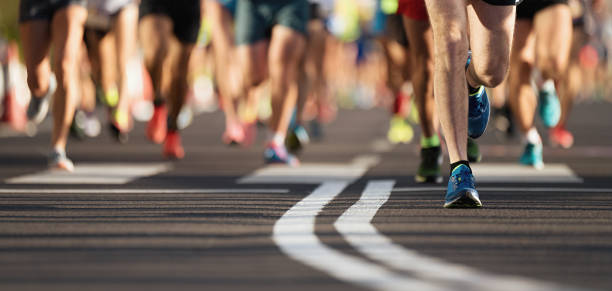 マラソン レース、市内道路上の人々 の足 - marathon running group of people jogging ストックフォトと画像