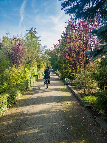 girl, riding bike away, in garden bike path