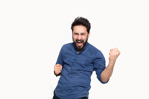 Portrait of cheering young man screaming in happiness against white background