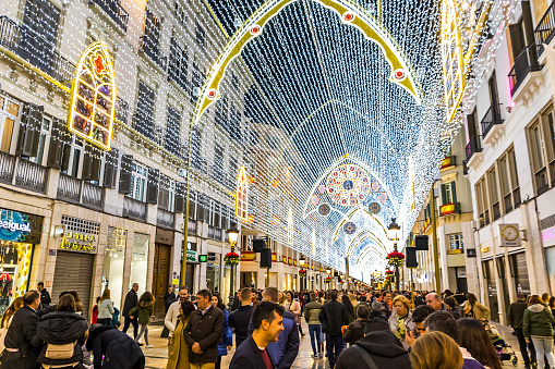 MALAGA, SPAIN - DECEMBER 9, 2017: Crowds of people walking on Calle Marques de Larios street, decorated with Christmas decorations. Most popular pedestrian street of Malaga, Andalusia, Spain