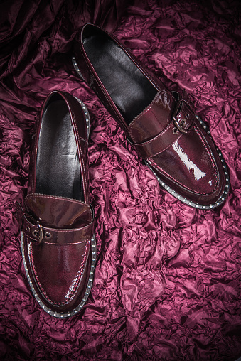 Burgundy Patent Leather Loafer Shoes on Burgundy Background