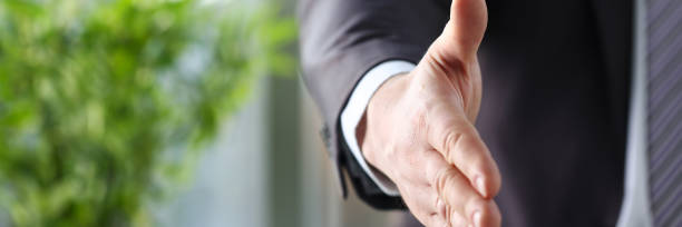 istock Man in suit and tie give hand as hello in office 1069114072