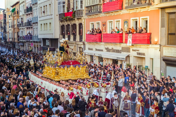 persone che partecipano alla processione nella settimana santa in una città spagnola - mask religious celebration horizontal easter foto e immagini stock