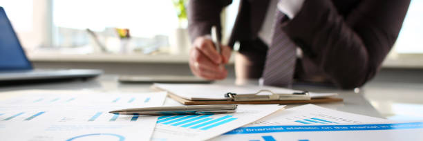 istock Silver pen lie at important paper on table in office 1069114354