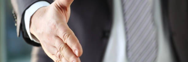 istock Man in suit and tie give hand as hello in office 1069114430