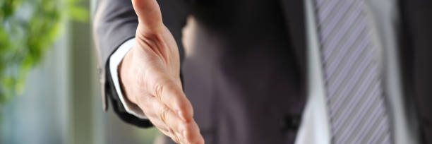 istock Man in suit and tie give hand as hello in office 1069114454