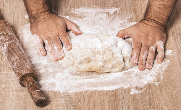 istock male chef kneads the dough 1069115870