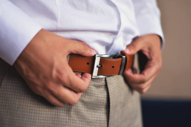 istock man adjust his belt of elegant suit. getting ready concept. 1069115938