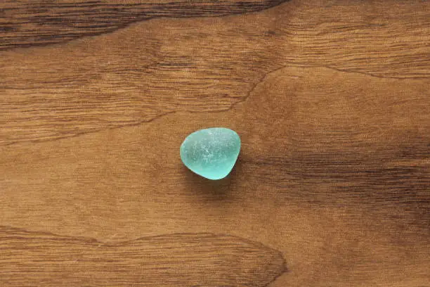 Sea glass seaglass. Small pebble color turquoise or tiffany. Wooden background.
