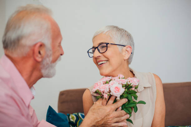 istock Mature woman receiving roses from her husband 1069118544