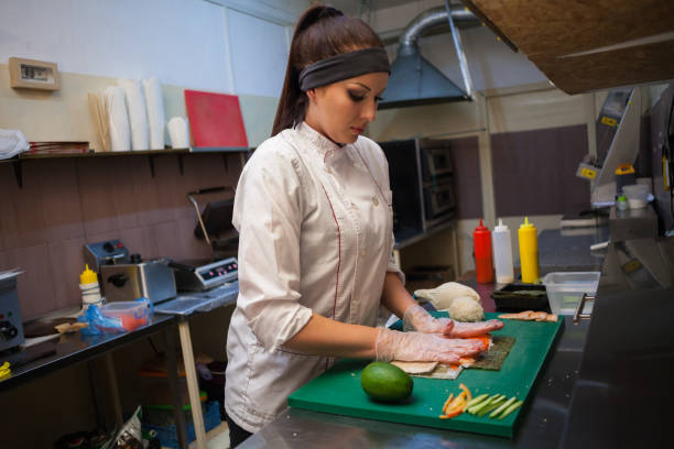 istock beautiful woman chef prepares sushi on restaurant kitchen 1069119762