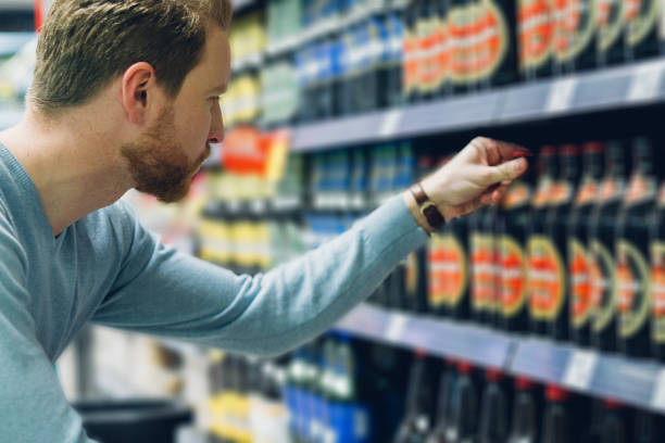 Young man buying beer Man buying alcohol at the liquor store alcohol shop stock pictures, royalty-free photos & images