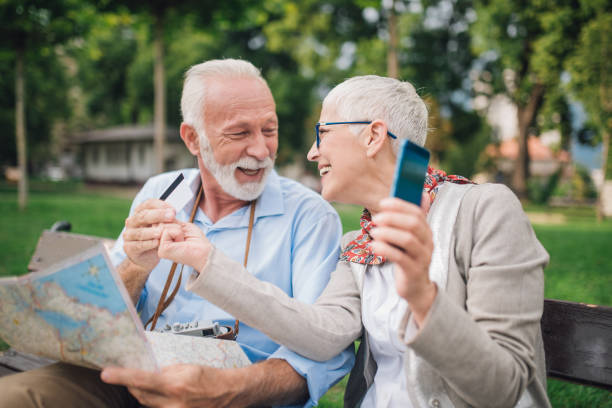 istock Happy tourists with mobile phone, credit card and a map 1069125242
