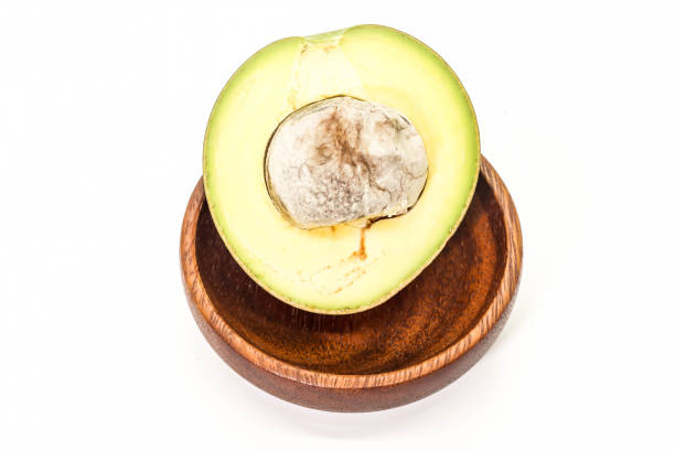 Half seed of green thai avocado on wooden ,white background