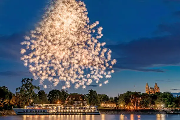 Fireworks over the Rhine with a ship and the cathedral in Speyer in Germany
