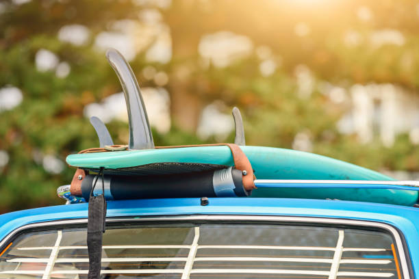 Surfboard on car roof rack Surfboard on roof rack of vintage car, South Australia surfboard fin stock pictures, royalty-free photos & images