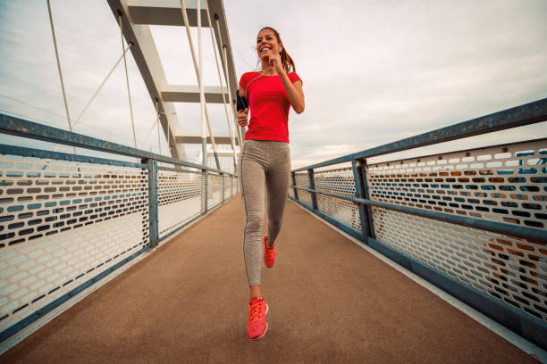 istock Young woman running outdoors in the city 1069134340