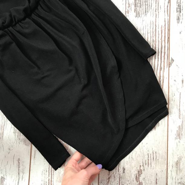 istock Black dress close-up on a wooden background 1069136688