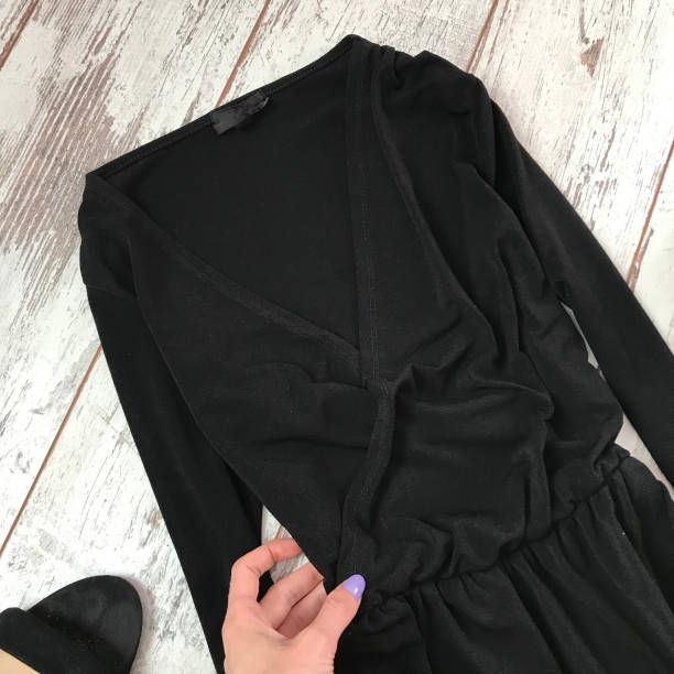 istock Black dress close-up on a wooden background 1069136770