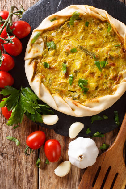 istock Freshly baked vegetarian potato pie with vegetables and herbs close-up on the table. vertical top view 1069150806