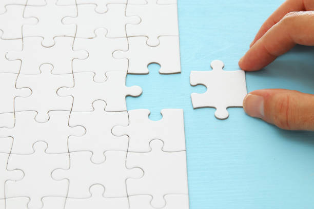 istock male hand putting the last piece in the puzzle. 1069151654