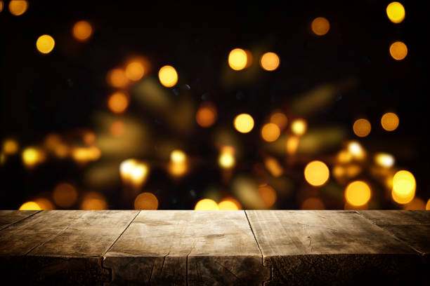 istock rustic wooden table in front of glitter black and gold bokeh lights. 1069151736