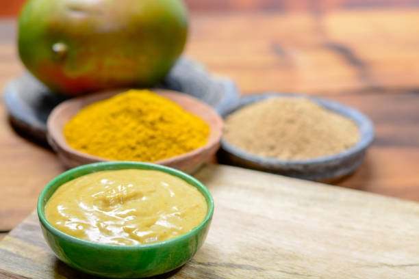 istock Tasty mango-curry sauce in small bowl ready to eat and bowls with mango and curry powder close up 1069158532