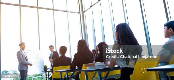 Group Of Attentive Adult Students With Speaker Giving A Talk Or Trainer In Classroom Or Seminar At Business Training To Success Of Target Stock Photo - Download Image Now