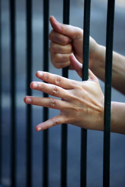 istock hand of prisoner in jail background. 1069160520