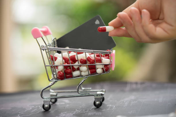 pile of capsule tablet in shopping cart with credit card. - vitamin pill picking up pill capsule imagens e fotografias de stock