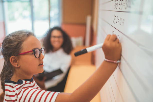 uczennica rozwiązywania matematyki na białej tablicy w klasie - child writing education nerd zdjęcia i obrazy z banku zdjęć